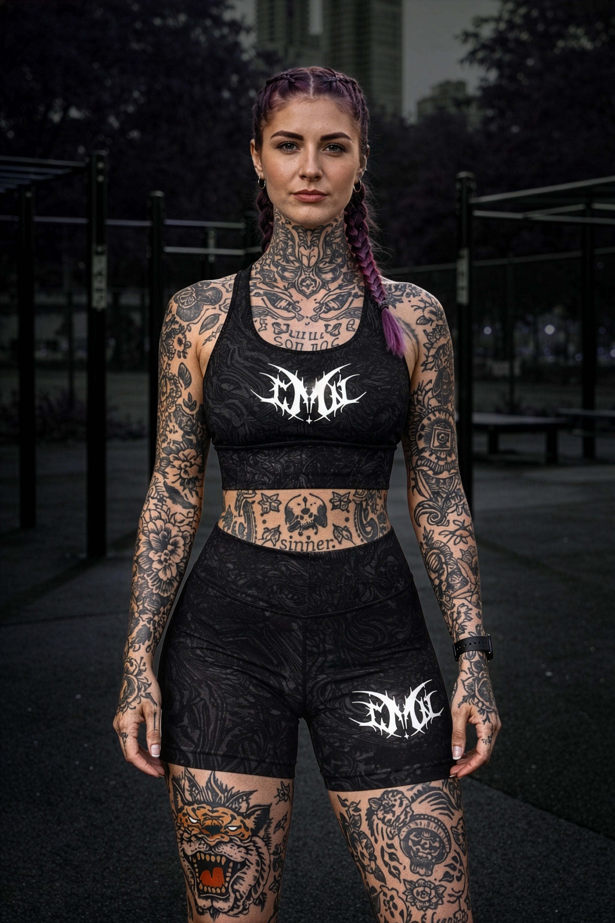 Femme portant l'outfit sportwear MCN, brassière et body short texturé sombre Logo MCN blanc