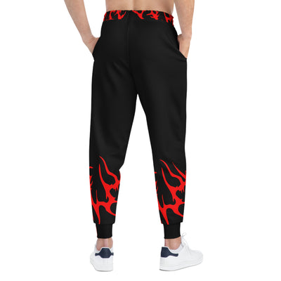 Jogging carotte noir, gros cordon blanc en polyester recyclé. marquage en sublimation. Design griffé CN/RedCore rouge vif sur le bandeau de taille et le bas des jambes. Porté par un homme, vue de dos.